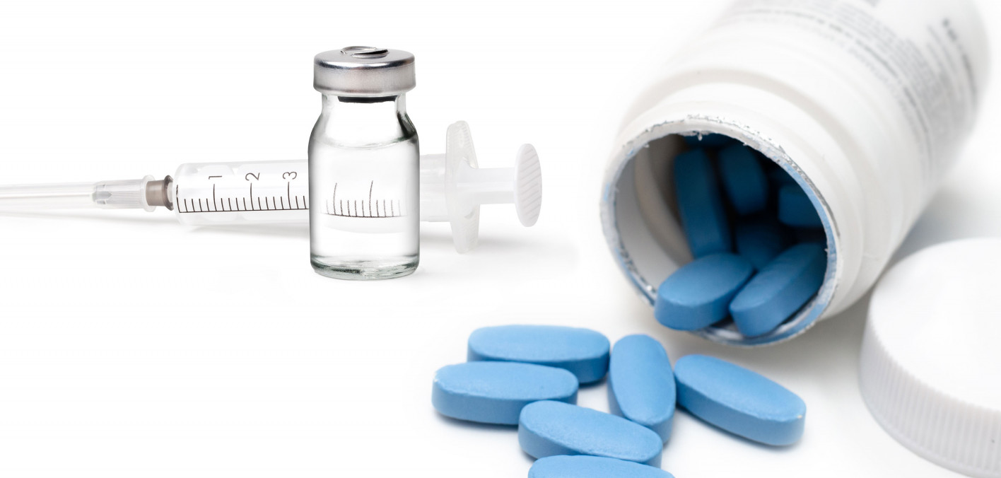 Image of blue pills next to a syringe with a liquid vial.